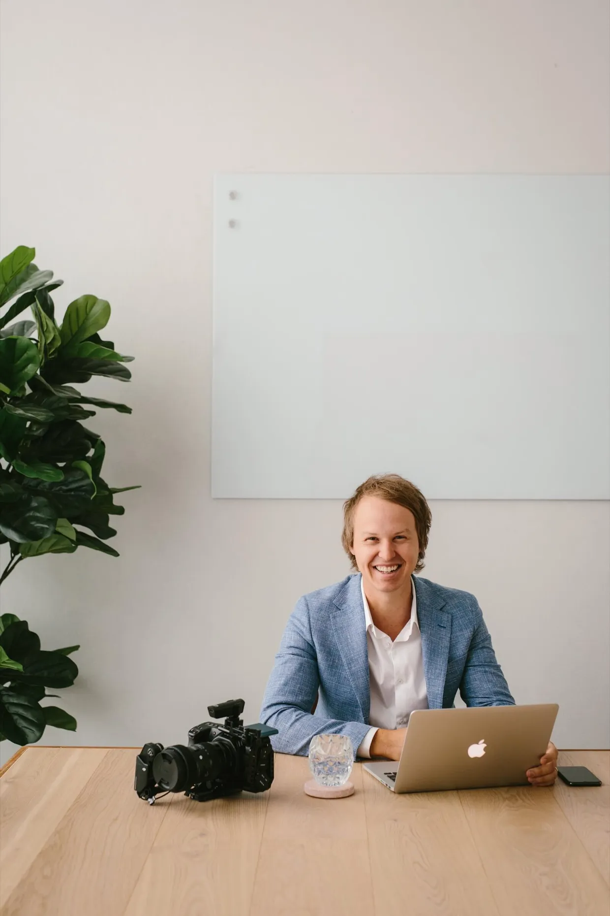 Casey Jones, founder of CJ&CO, at his desk with a laptop and camera