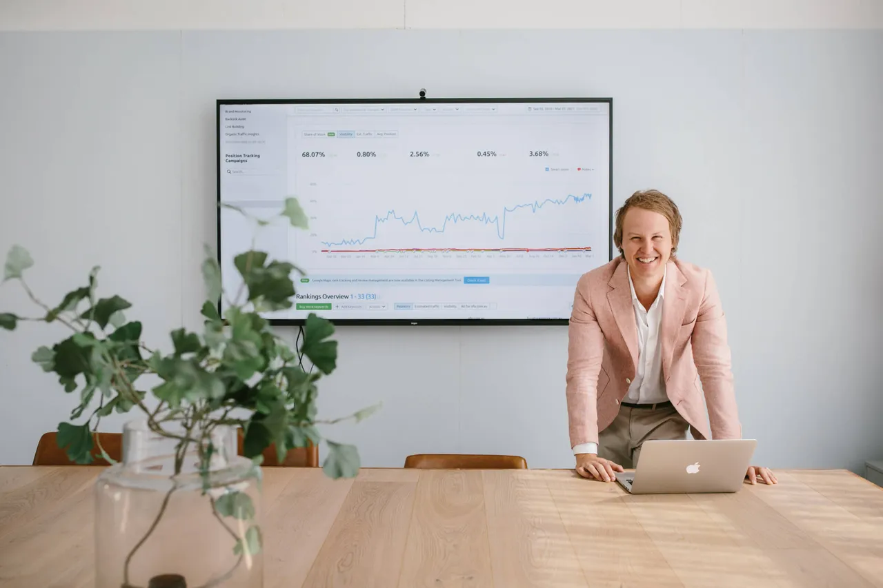 Casey Jones, founder of CJ&CO, in the boardroom beside a search rankings dashboard