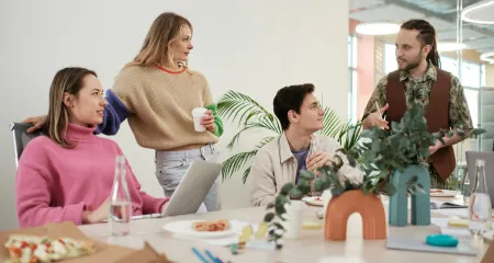 A group of people sitting around a table in an office discussing brand strategy