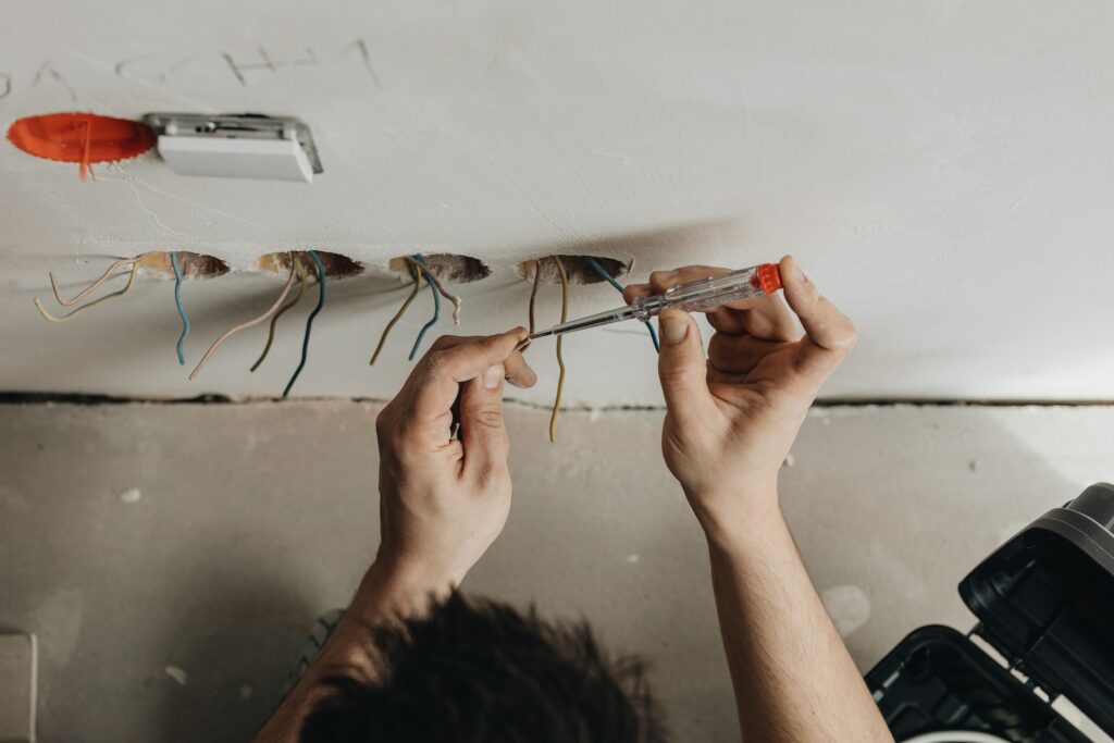 A Redlands electrician is working on electrical wiring in a room.