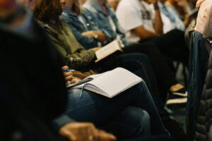 Audience members taking notes during an employee training seminar.