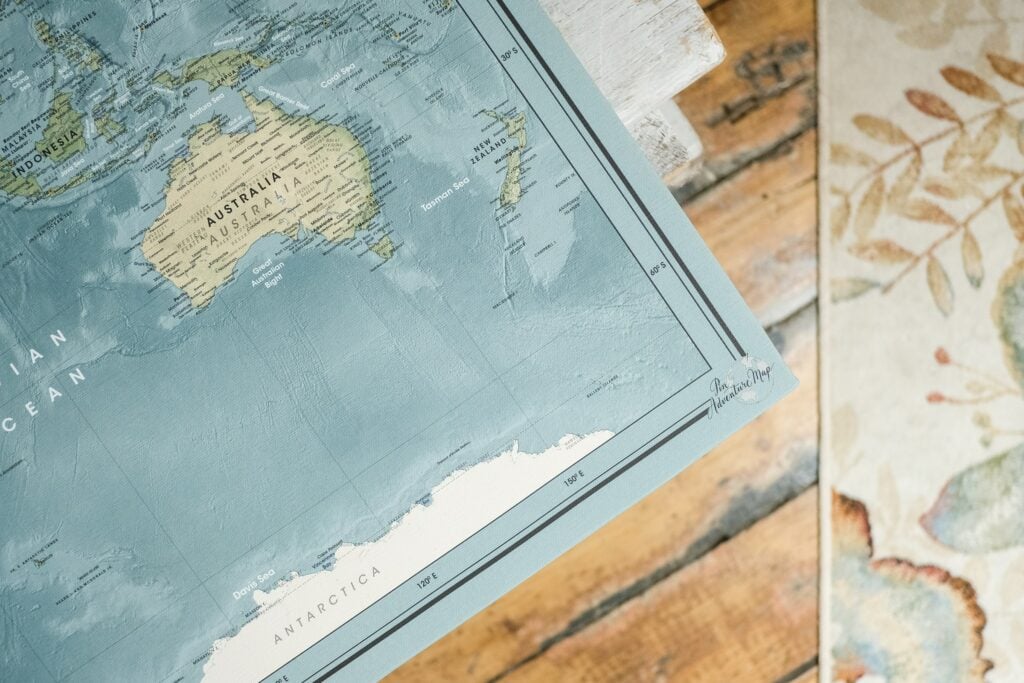 A big map of the world on a wooden floor.