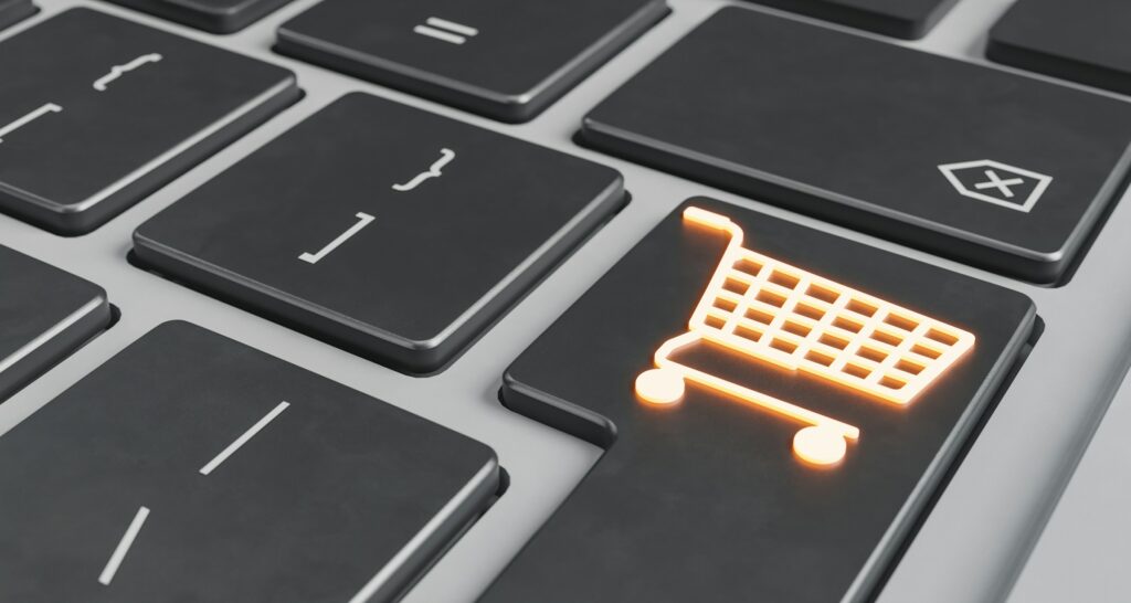 A close-up of a keyboard features an illuminated shopping cart icon on the enter key, symbolizing the efficiency of online shopping. It's as reassuring as knowing how long it takes for Amazon to refund, bringing convenience right to your fingertips.