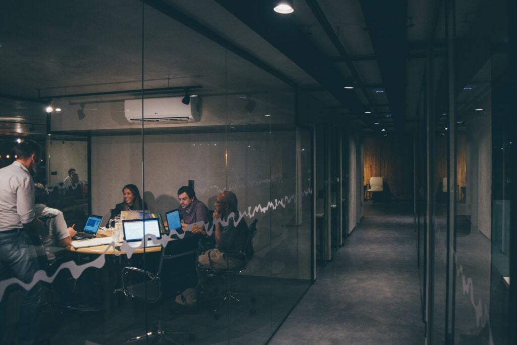 A group of people sitting around a table in a workplace conference room.