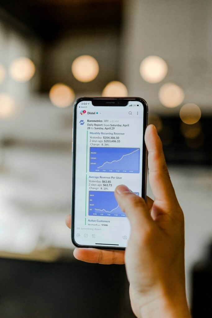 A Person Holding Up A Phone Displaying An Enhanced Graph.