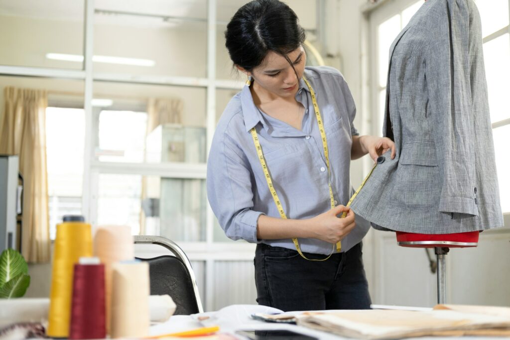 A woman measuring a mannequin to become a fashion designer.