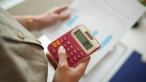A woman is using a calculator to calculate rental yield for savvy investors.