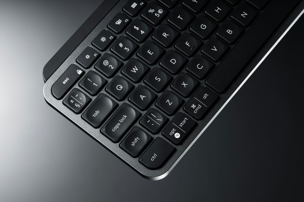 A Close Up Of A Logitech Keyboard On A Grey Background.