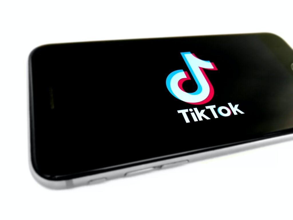 The logo of TikTok is displayed on a smartphone, demonstrating How to Delete a Collection on Tiktok.