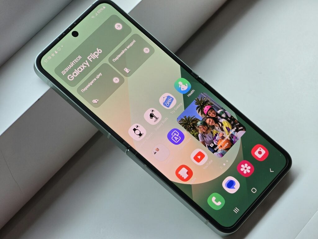 A smartphone displaying its home screen with various app icons and a family photo widget, highlighting the ease of exploring features like extending ring time on Samsung devices.