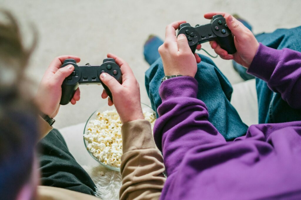 Two Individuals Playing Video Games On A Couch.