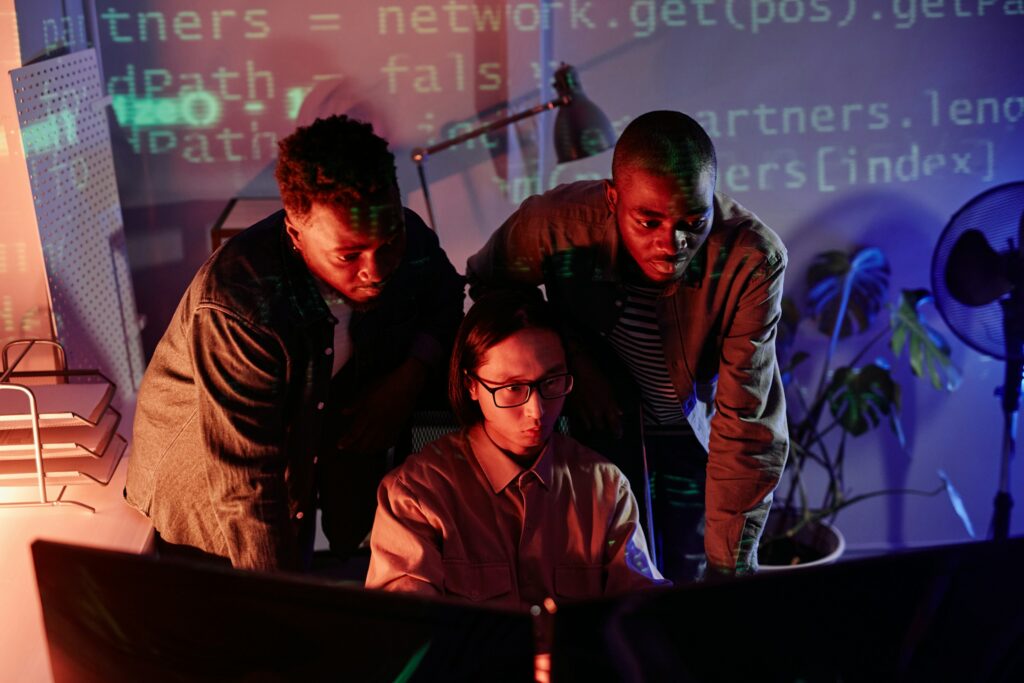 A Group Of People Looking At A Computer Screen, Learning How To Unblock Websites.