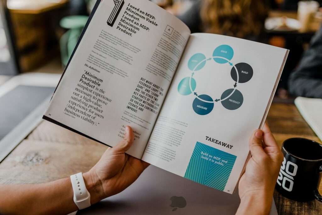A person holding a book with diagrams on legitimate affiliate marketing strategies.
