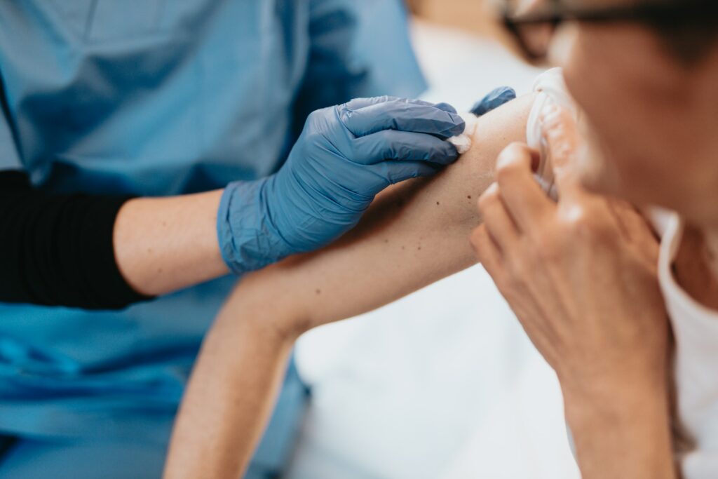 A woman in Australia is receiving a vaccine on her arm, utilizing Medicare or potentially covered by her Private Health Insurance.