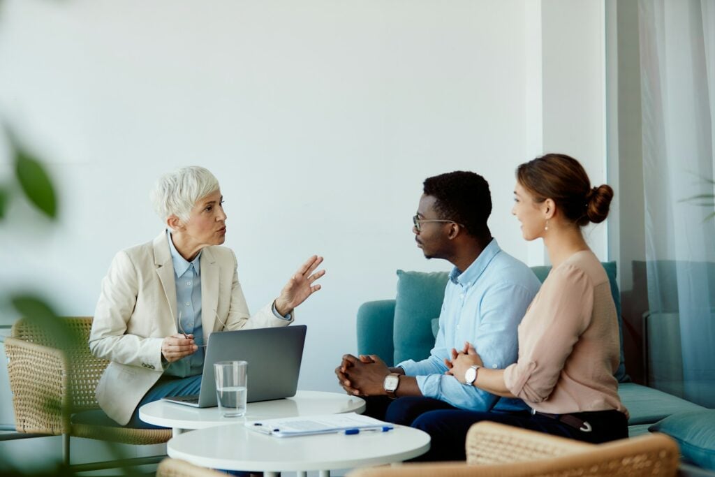 A group of people sitting around a table discussing Lifetime Health Cover and health insurance in Australia.