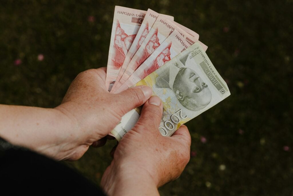 A woman's hands holding a bunch of money showcasing her impressive earnings.