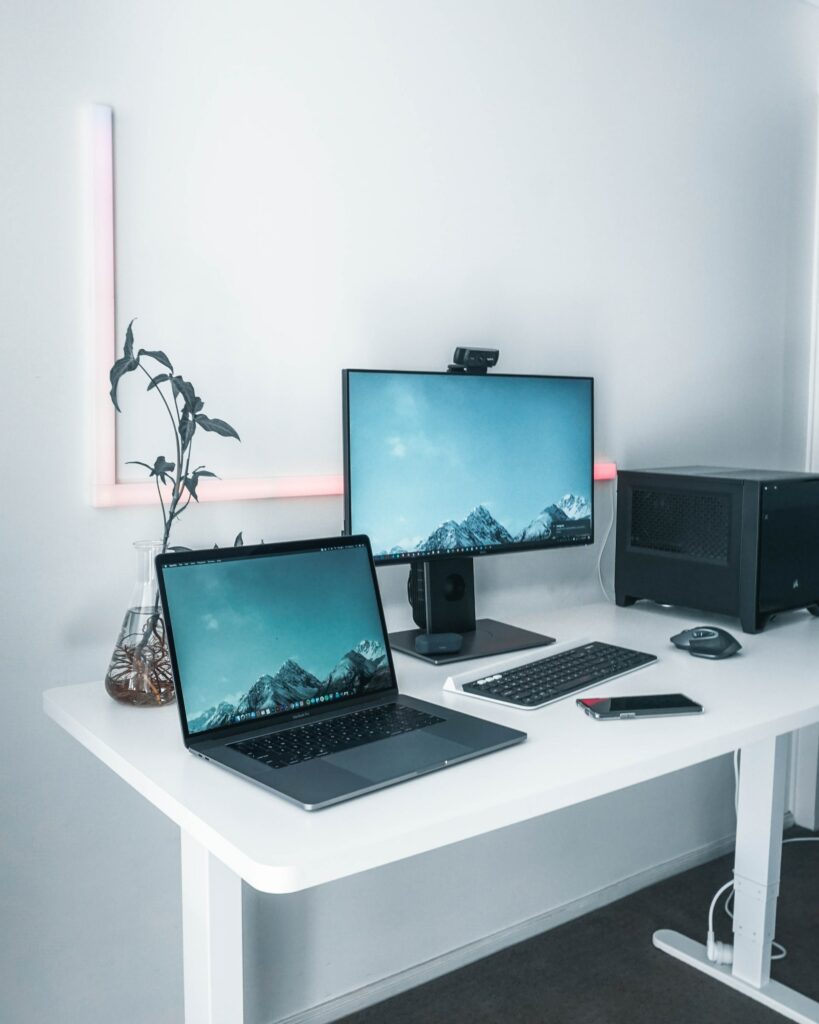 A white desk with two monitors and a laptop, showcasing a setup for programmatic advertising.