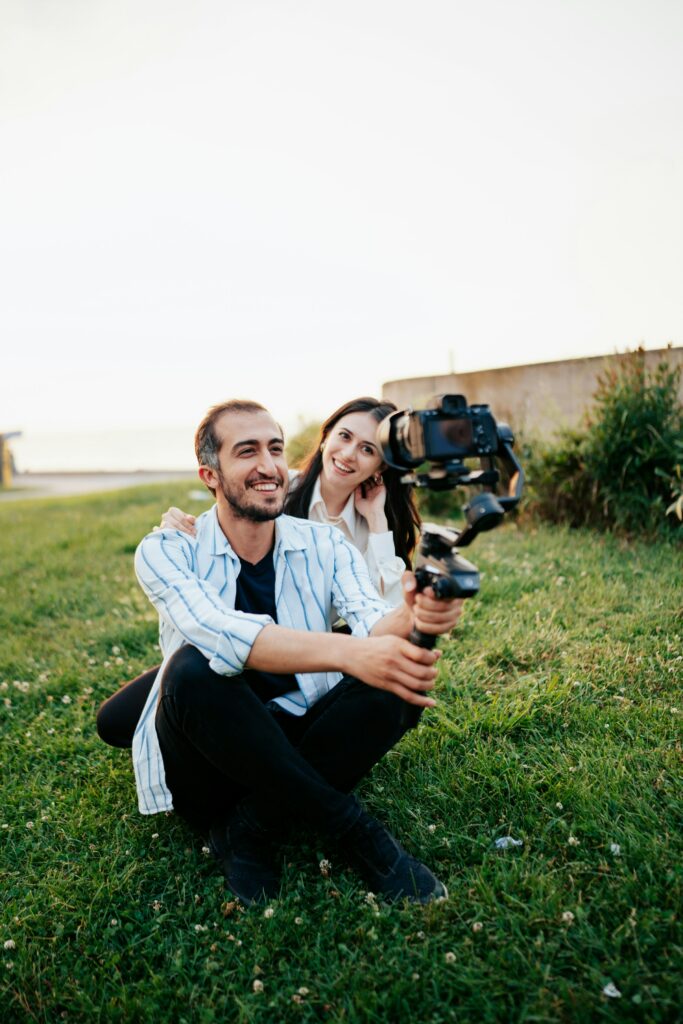 A Man And Woman Using A Gimbal To Take A Selfie.