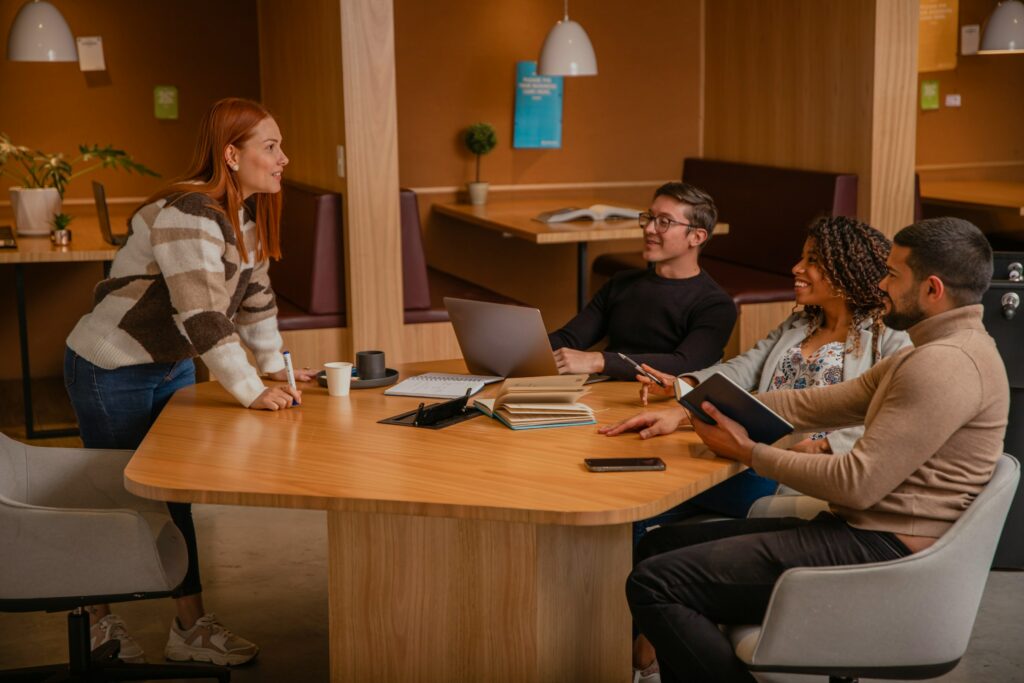 A group of people sitting around a table in an office, discussing matter.
