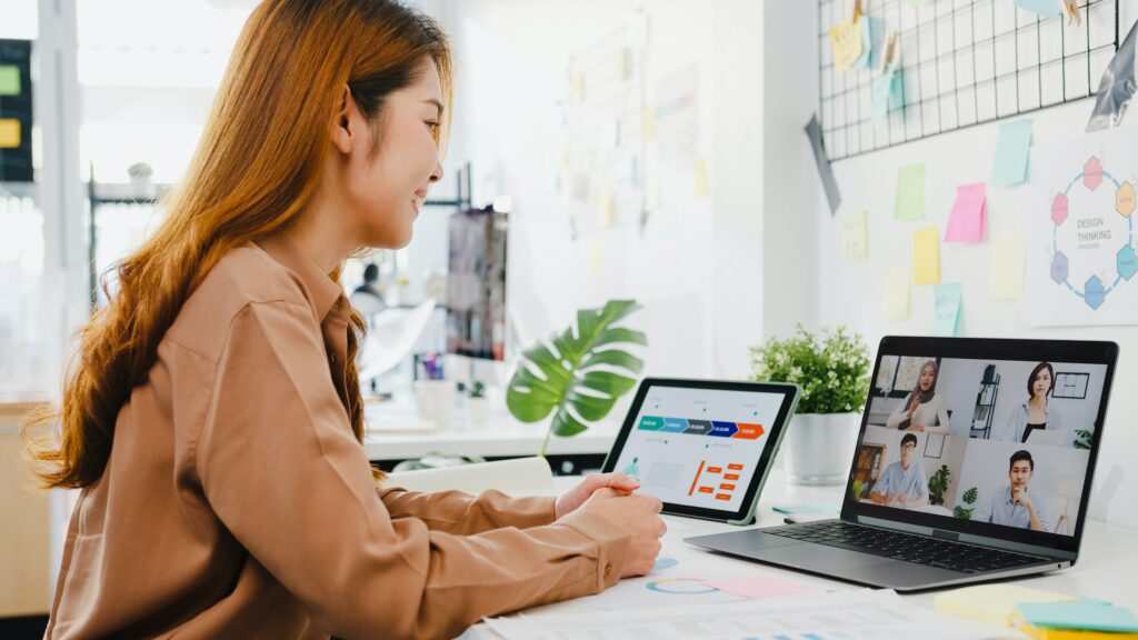 A woman attending an important webinar while sitting at a desk with a laptop in front of her.