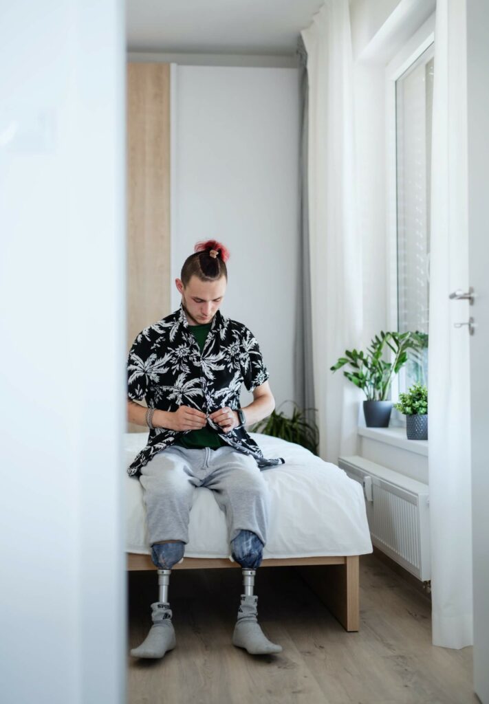 Australian NDIS participant sitting on his bed