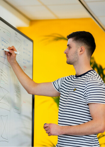 A man designing structure on a whiteboard