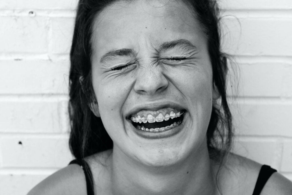 Girl with braces smiling after dental work
