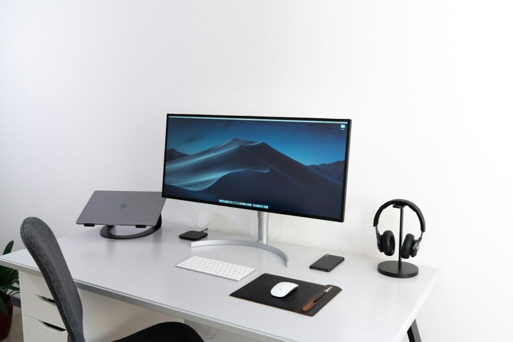 An essentials for a home office setup in 2024, featuring a desk with a monitor, keyboard, and mouse.