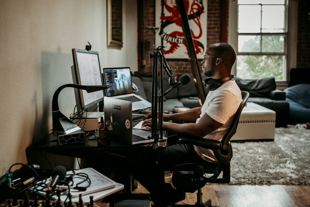 A man sits at a desk in front of a microphone, passionately sharing valuable insights on how to be a content creator.