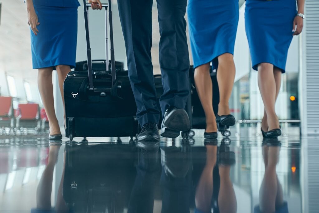 A group of flight attendants walking with luggage in an airport on an Australian journey.