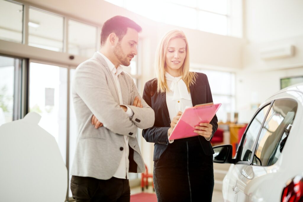 A man and woman looking at a car in a showroom while considering financing options in Australia.
