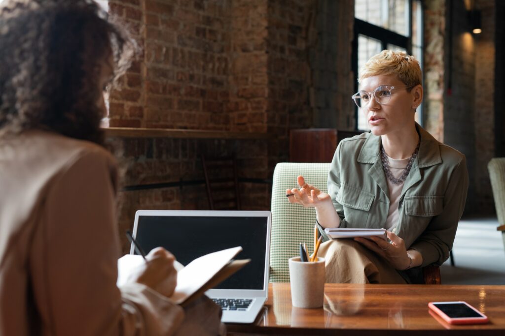 Two women discussing how to start a consulting business over coffee.