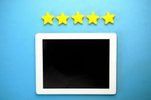 A tablet with a blank screen is displayed on a blue background, with five yellow stars lined up above it.