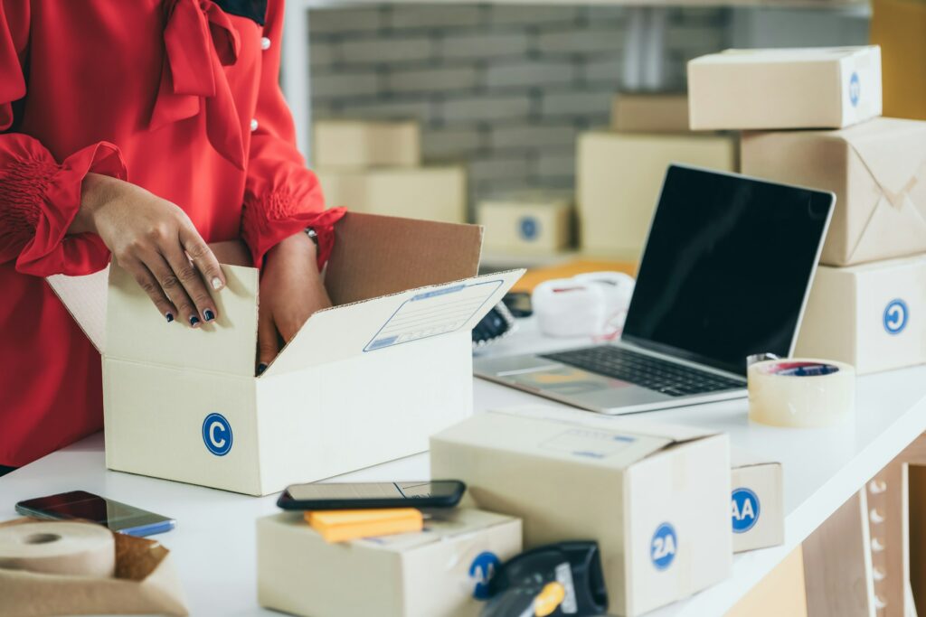 A woman is placing boxes on a desk.