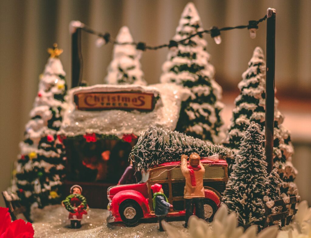 A festive Christmas scene featuring a vibrant red truck and a beautifully decorated Christmas tree.