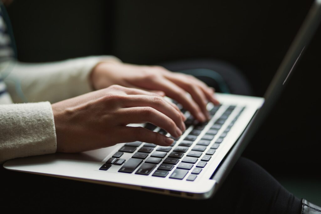 A woman's hands typing on a laptop, exploring Thomson Reuters' AI and ML advancements.