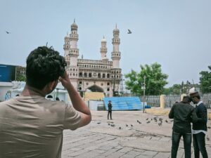 A man photographs pigeons near a mosque, exploring SEO potential to enhance site rankings.