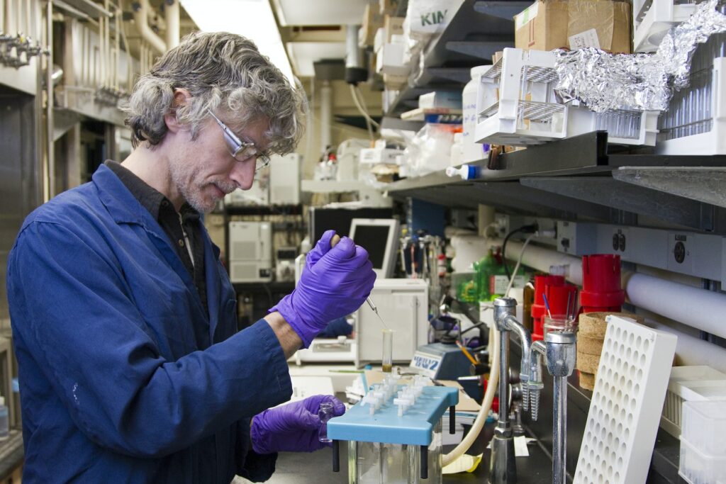 A man conducting protein research using advanced technology in a lab.