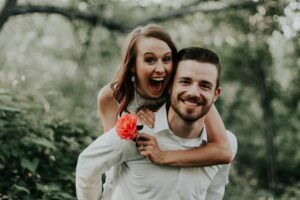 A couple embracing in the forest for their engagement shoot, utilizing fan-driven marketing for higher ROI.