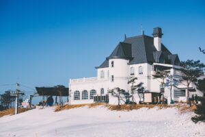 A snow covered hill with a white building.