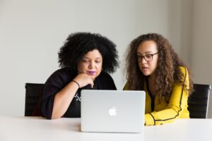Two women sitting at a table exploring AI in marketing.