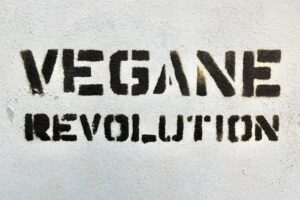 The word vegan revolution is painted on a wall during the new technological era.