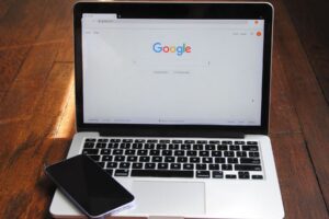 A laptop and cell phone paired for optimizing content with proven SEO strategies for higher rankings.
