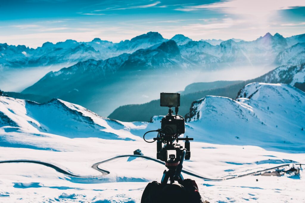 Keywords: camera, snowy mountain
Revised description: A man with a camera capturing a snowy mountain.