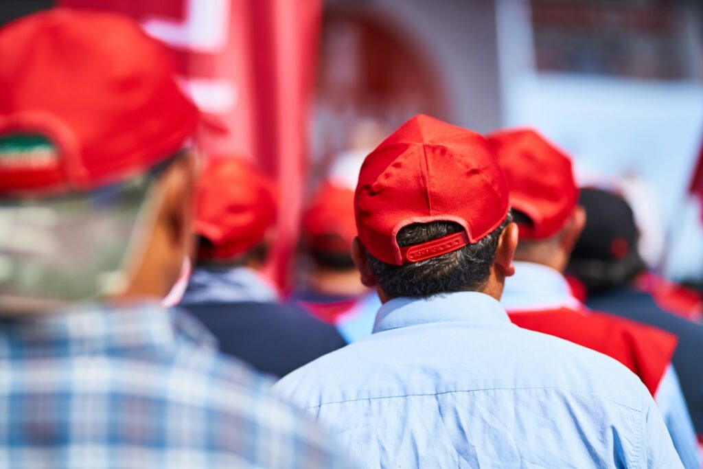 A group of people showcasing innovations wearing red hats.