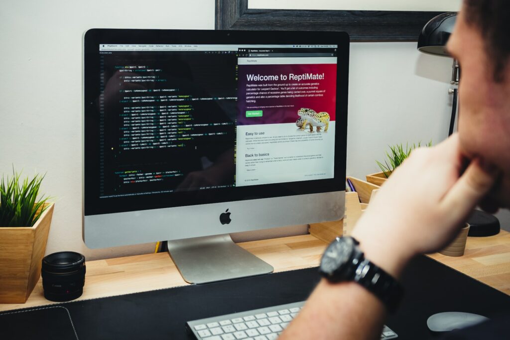 A man sitting at a desk looking at a computer screen, mastering advanced CSS techniques.