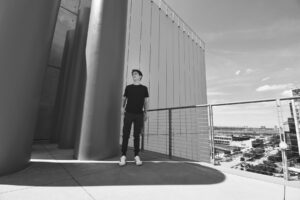 A black and white photo of a man standing on a balcony integrating smart biosensors for efficient on-chip learning.
