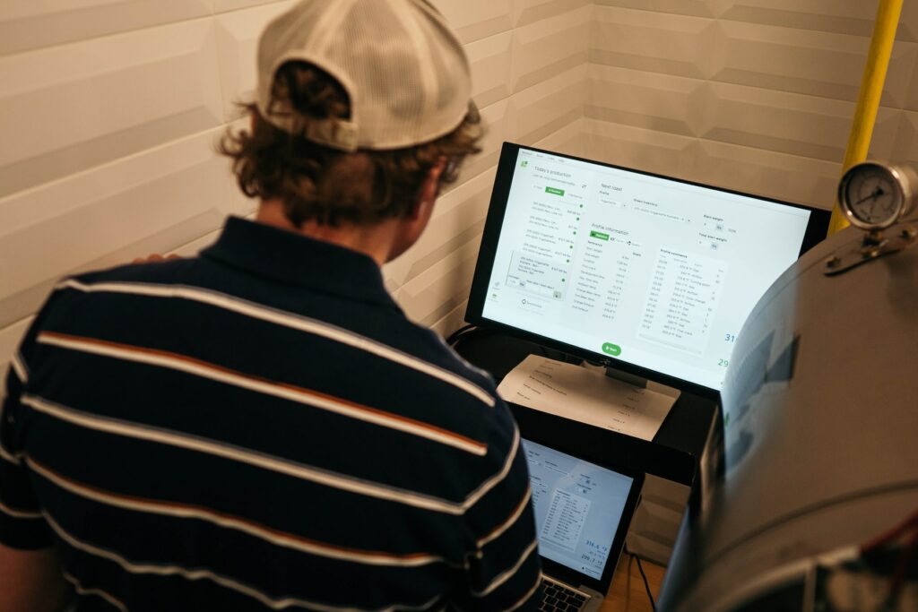 A man in a hat is looking at a computer screen while utilizing TikTok's new attribution analytics tool for superior ad performance.