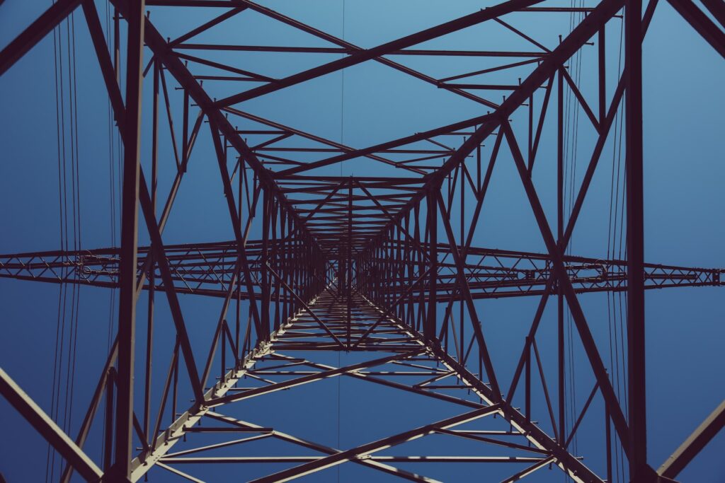 A close up of a power tower against a blue sky.
