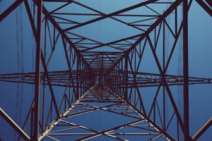 A close up of a power tower against a blue sky.